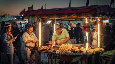 İstanbul, Türkiye - Eylül 2021: Tarihi merkez ve eski İstanbul kenti Eminonu 'da, kalabalık Eminonu ilçesinde mısır ve kestane satan sokak yemekleri stanesi.