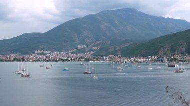 Türkiye 'de Fethiye marinası ve limanının havadan görüntüsü, dağlarla çevrili sayısız yat, yelkenli ve yelkenli tekneleri var.