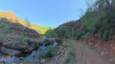 Türkiye 'nin Mugla kentindeki Toparlar Şelalesi' ne giden kanyon boyunca kaya kayalıkları ve yemyeşil bitki örtüsüyle yürüyüş yapmak