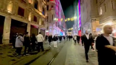 İstanbul, Türkiye - 21 Kasım 2025: Beyoğlu 'ndaki kalabalık İstiklal Caddesi' nin zaman aşımı videosu. İstiklal Caddesi çok popüler bir turistik merkezdir. Birçok dükkan ve kalabalık vardır.