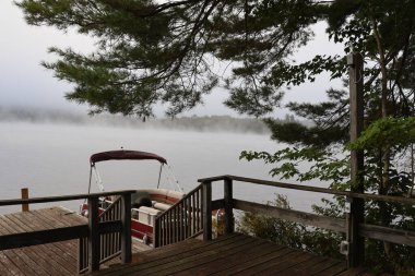 a beautiful view of a lake with a wooden dock on the background of a forest