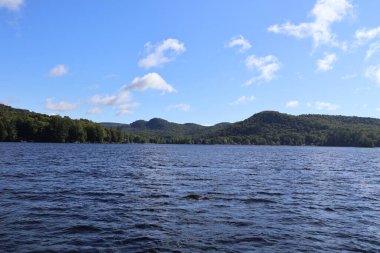 Mavi gökyüzü ve Adirondacks dağları ile güzel bir göl.
