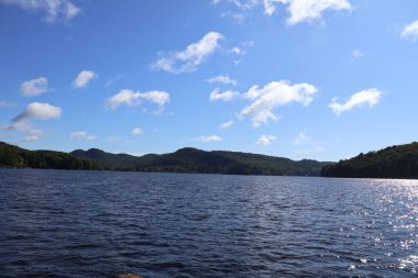 Mavi gökyüzü ve Adirondacks dağları ile güzel bir göl.