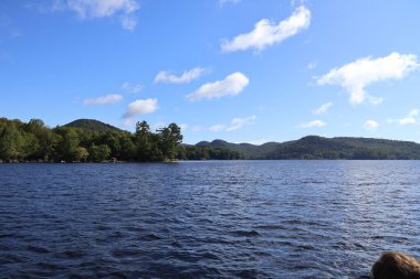 Mavi gökyüzü ve Adirondacks dağları ile güzel bir göl.