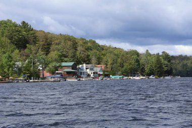 rıhtımı ve kayıkhanesi olan göl kenarındaki yazlık evler..