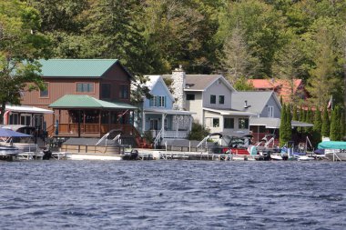 rıhtımı ve kayıkhanesi olan göl kenarındaki yazlık evler..
