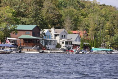 rıhtımı ve kayıkhanesi olan göl kenarındaki yazlık evler..