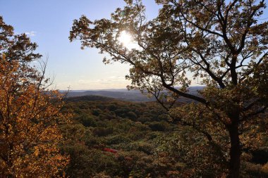 Güzel sonbahar günbatımı ve dağlarda ve vadilerde renkli ağaçlarla manzara