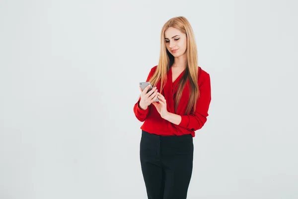 Menina em camisa vermelha usando smartphone — Fotografia de Stock