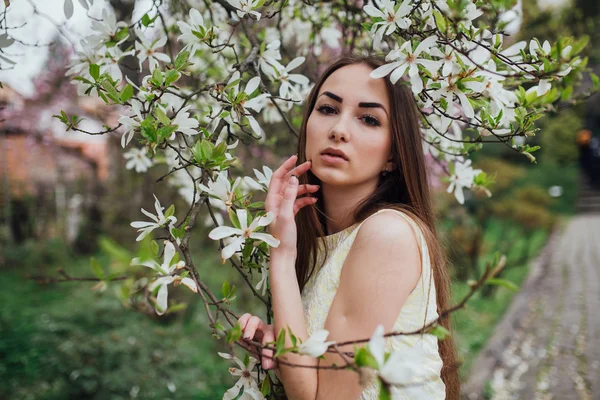 Gyönyörű lány magnolia közelében — Stock Fotó