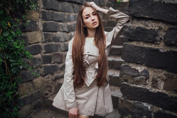 Jovem mulher posando perto de parede de tijolo — Fotografia de Stock