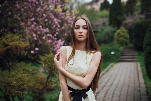 Gyönyörű lány magnolia közelében — Stock Fotó