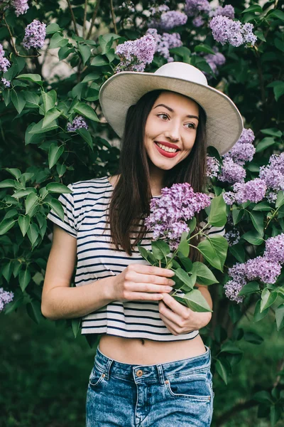 Menina bonita posando perto de árvore lilás — Fotografia de Stock