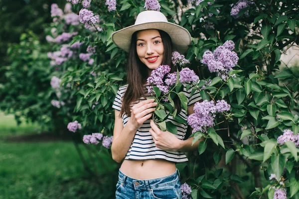 Mooi meisje poseren in de buurt van lila boom — Stockfoto