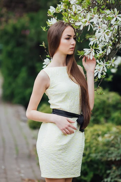 Vacker flicka nära magnolia — Stockfoto