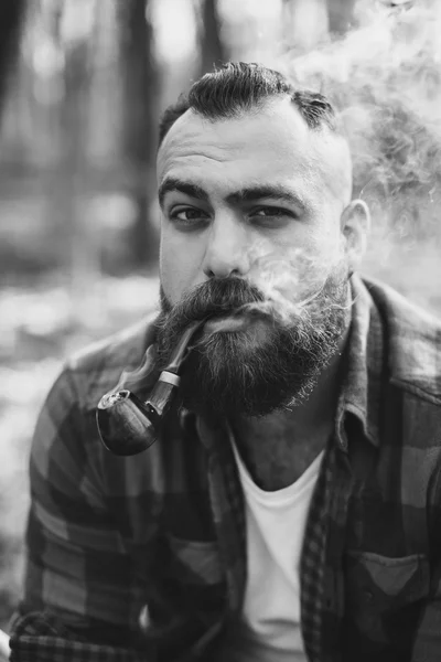 Бородатый мужчина курит трубку — стоковое фото