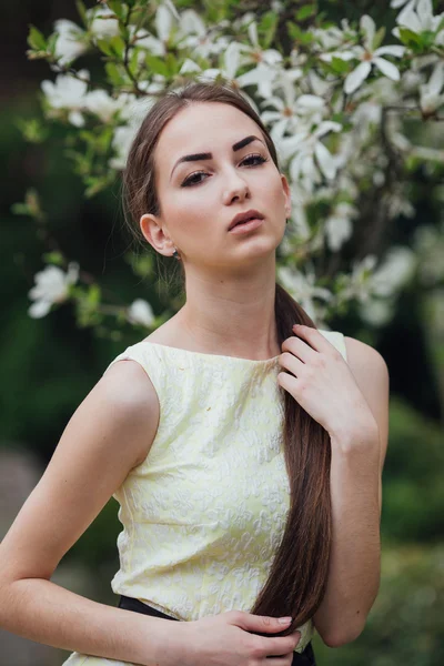 Menina bonita perto de magnólia — Fotografia de Stock