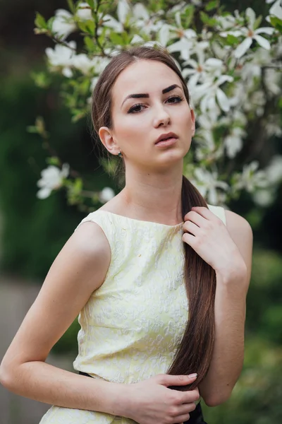 Menina bonita perto de magnólia — Fotografia de Stock