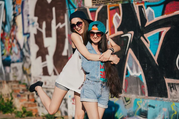 Giovani ragazze vicino muro graffiti — Foto Stock