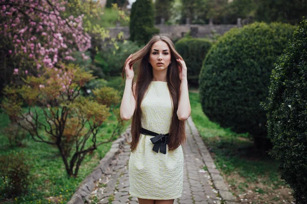 Gyönyörű lány magnolia közelében — Stock Fotó