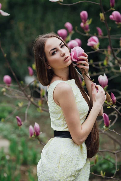 Mooi meisje in de buurt van magnolia — Stockfoto