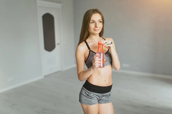 Chica joven con botella de agua después del entrenamiento — Foto de Stock