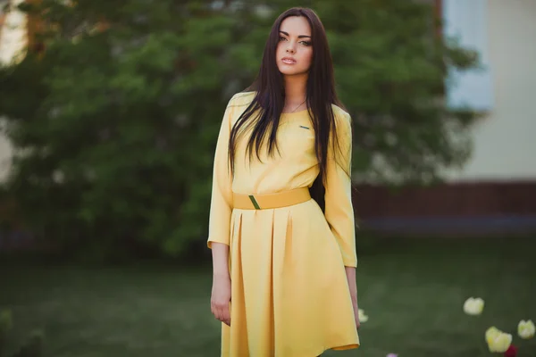 Молода жінка в жовтій сукні — стокове фото