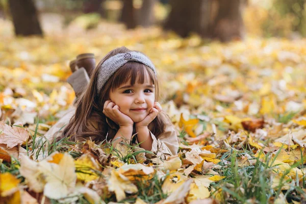 Güz Parkındaki Sarı Yaprakların Arasında Bej Ceketli Mutlu Güzel Küçük — Stok fotoğraf