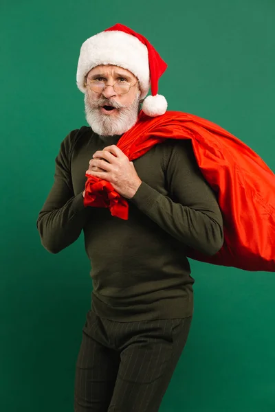 Gelukkig Bebaarde Moderne Santa Claus Houden Rode Tas Groene Achtergrond — Stockfoto