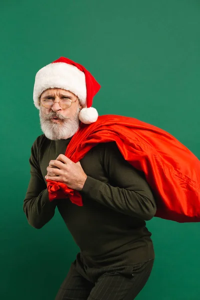 Gelukkig Bebaarde Moderne Santa Claus Houden Rode Tas Groene Achtergrond — Stockfoto