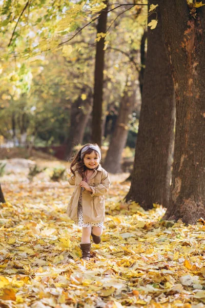 Feliz Hermosa Niña Abrigo Beige Corre Sosteniendo Una Hoja Arce —  Fotos de Stock