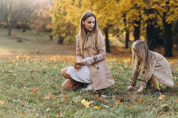 快乐的妈妈和她美丽的女儿在秋天的公园里散步 玩得很开心 — 图库照片