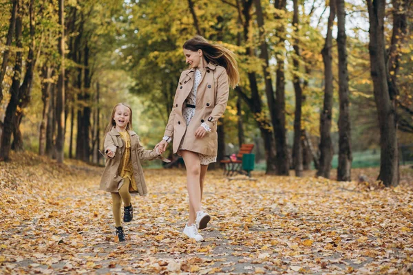 快乐的妈妈和她美丽的女儿在秋天的公园里散步 玩得很开心 — 图库照片