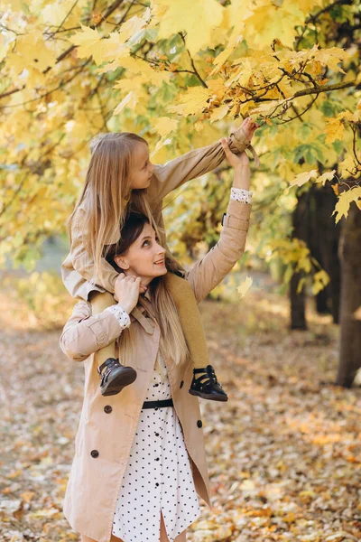幸せな母親と彼女の美しい娘は楽しみを持っており 秋の公園を歩く — ストック写真