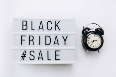Creative Top view düz promosyon kompozisyonu alarm saati ve ışık kutusu beyaz arkaplan kopyalama alanı üzerinde Kara Cuma satış metni