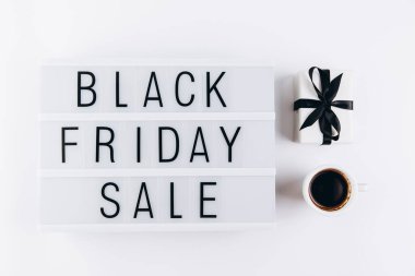 Creative Top view düz promosyon kompozisyonu bir fincan kahve, hediye ve ışık kutusu beyaz arkaplan fotokopi alanı üzerinde Kara Cuma satış metni