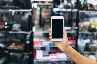 İş yapmak ya da bankacılık için akıllı telefon kullanmak ya da bulanık alışveriş merkezinin arka planında online alışveriş yapmak