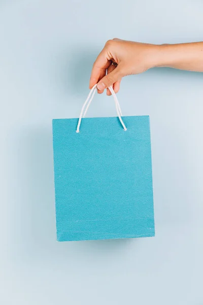 Mano Femenina Sosteniendo Bolsa Papel Azul Aislada Sobre Fondo Azul — Foto de Stock