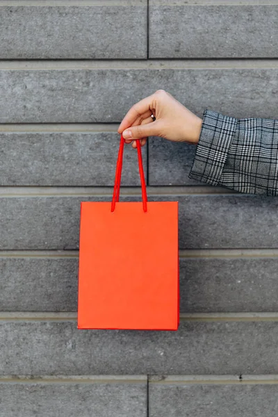 Mujer Traje Gris Sostiene Bolsa Papel Rojo Sobre Fondo Pared — Foto de Stock