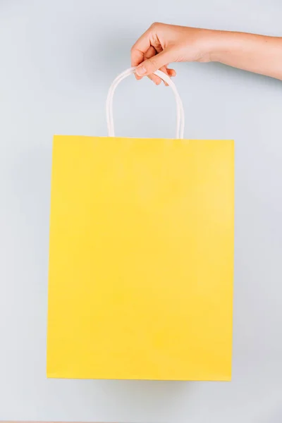 Жіноча Рука Тримає Жовтий Паперовий Мішок Ізольовано Синьому Фоні — стокове фото