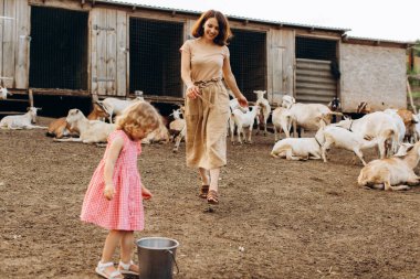Mutlu anne ve kızı keçilerin arasında bir eko çiftliğinde vakit geçiriyorlar..