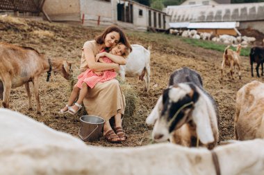 Mutlu anne ve kızı keçilerin arasında bir eko çiftliğinde vakit geçiriyorlar..
