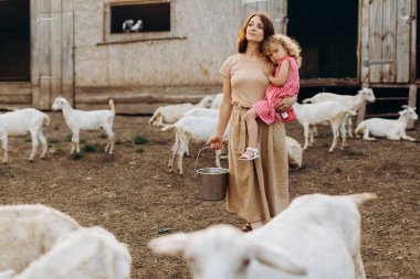 Mutlu anne ve kızı keçilerin arasında bir eko çiftliğinde vakit geçiriyorlar..