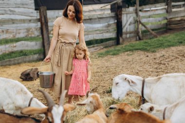 Mutlu anne ve kızı keçilerin arasında bir eko çiftliğinde vakit geçiriyorlar..