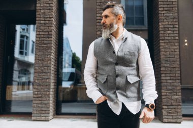 Gri sakallı ve vahşi bir adamın portresi. Temiz kentsel alanlarda vakit geçiriyor..