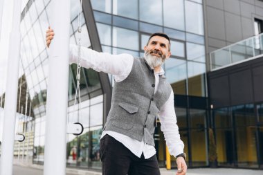 Gri sakallı ve vahşi bir adamın portresi. Temiz kentsel alanlarda vakit geçiriyor..