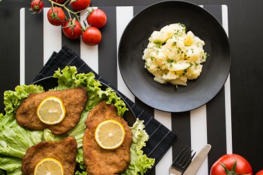 Şnitzel hizmet yeşillik ve limon ile