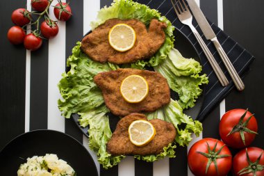 Schnitzel serve with greens and lemon clipart