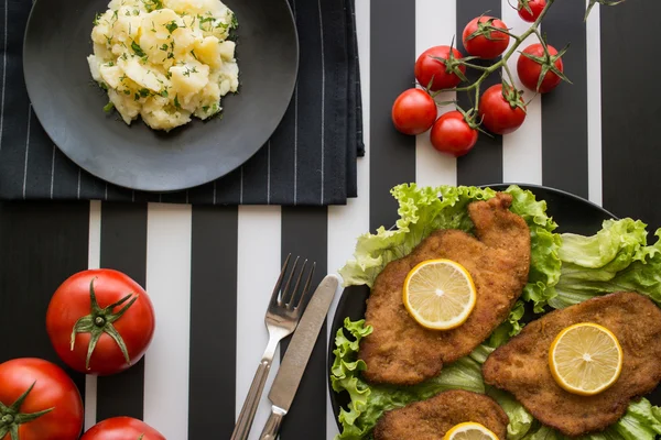 Schnitzel mit Gemüse und Zitrone servieren — Stockfoto
