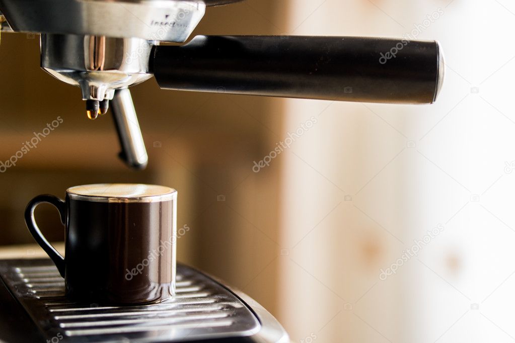 Espresso machine making coffee and pouring in a brown cup Stock Photo